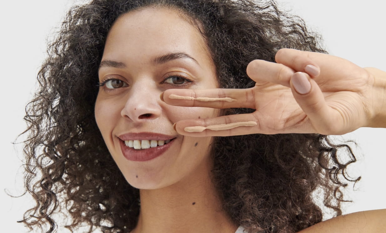 Model applying glow sunscreen